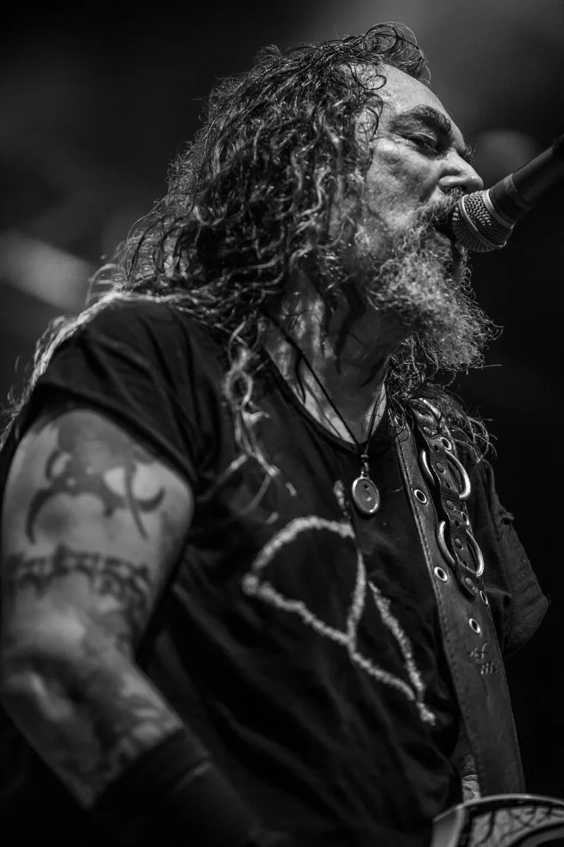 Max Cavalera, chanteur de Soulfly, capturé en plein chant sous les projecteurs lors d'un concert