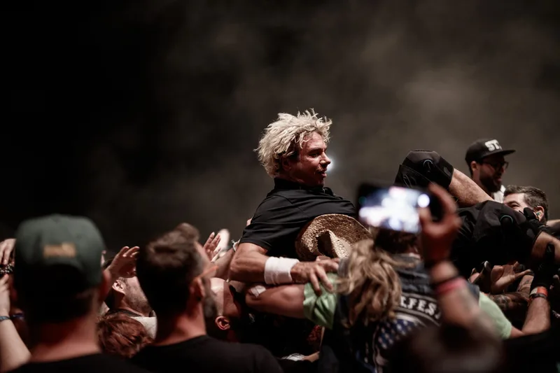 Le chanteur d'Enhancer en plein slam porté par la foule en crowd surfing pendant un concert