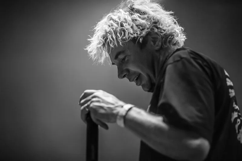 Sourire authentique partagé par le chanteur d'Enhancer en fin de morceau sur scène