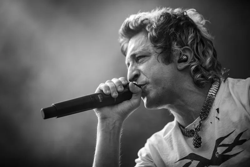 Clem Richard, chanteur du groupe Ashen figé en noir et blanc en pleine performance vocale