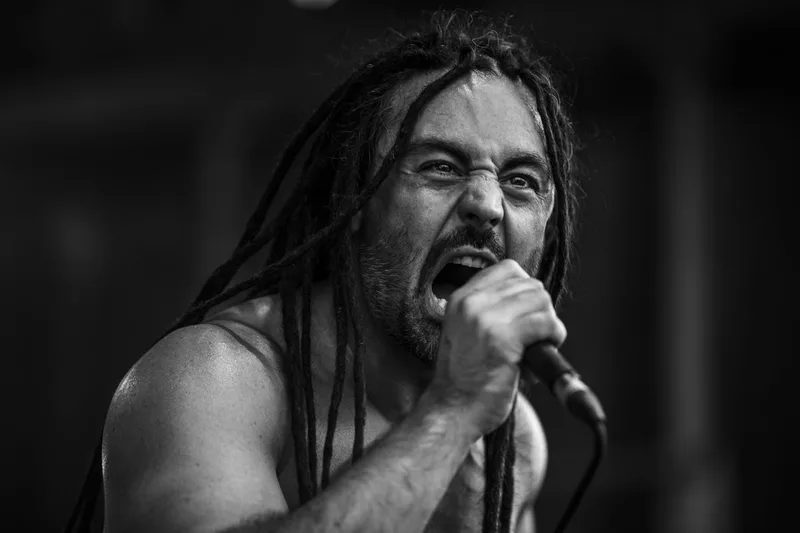 Le chanteur d'Olden World Limit avec ses dreadlocks en mouvement lors d'un cri sur scène