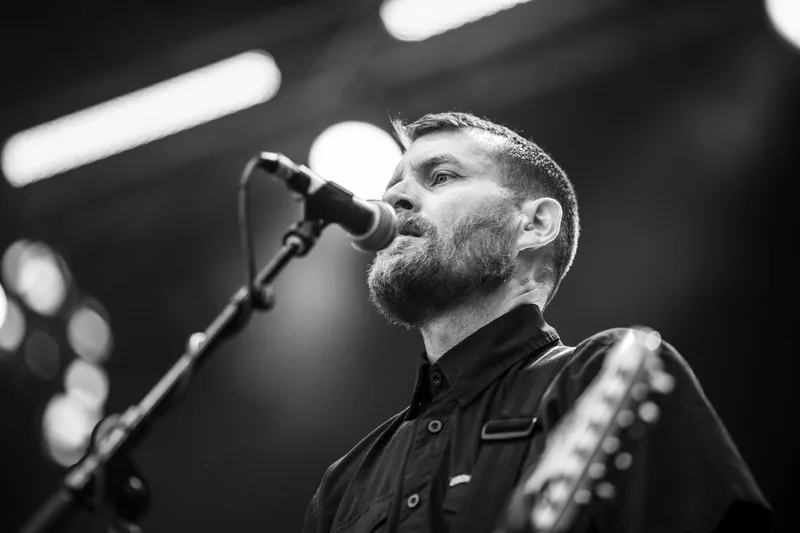 Le guitariste de Stick To Your Guns figé en noir et blanc lors d'une performance live