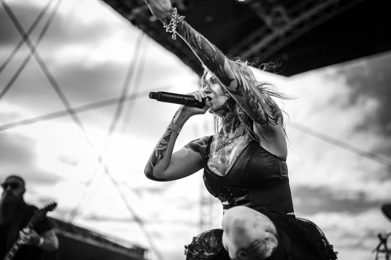 Rachel Aspe de Cage Fight, regard intense et tatouages visibles sous un ciel d'orage