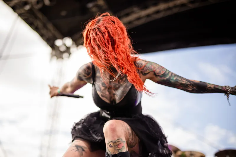Rachel Aspe, chanteuse tatouée de Cage Fight, affichant une attitude scénique déterminée