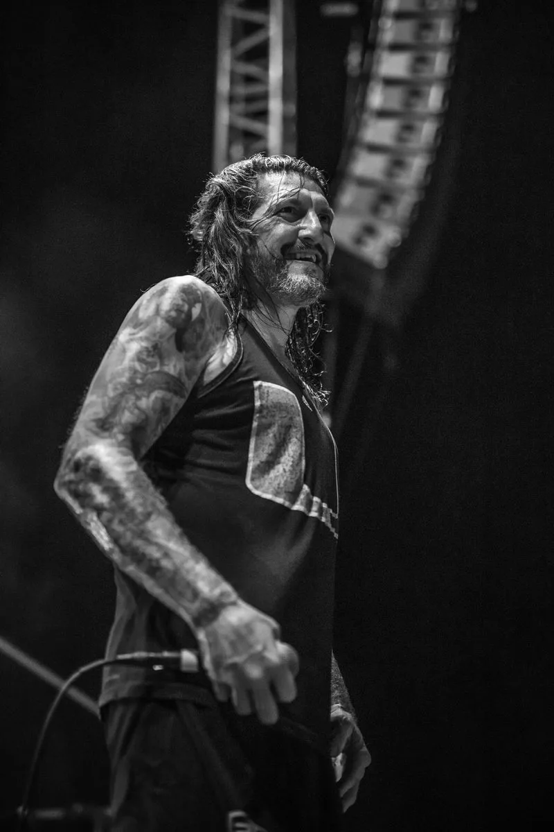 Sourire complice de Freddy Cricien, chanteur de Madball, pris sur le vif sur scène en noir et blanc