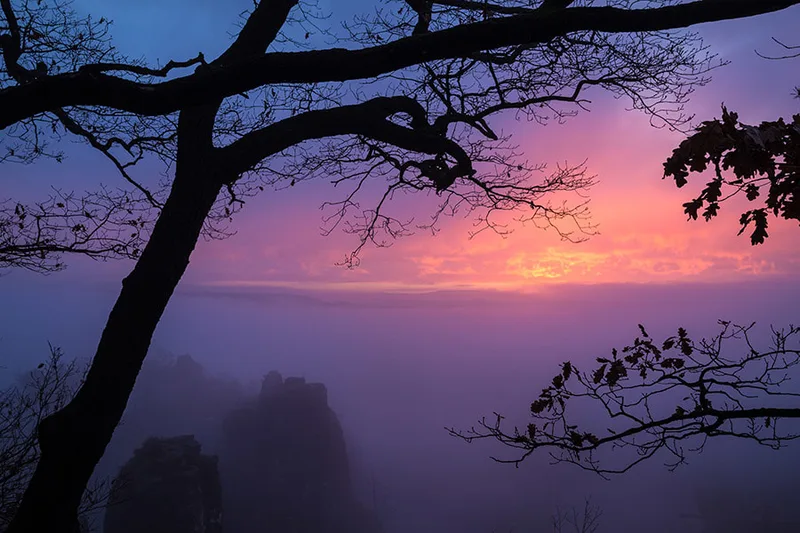 Lever de soleil spectaculaire sur les formations rocheuses et la brume colorée de Bastei