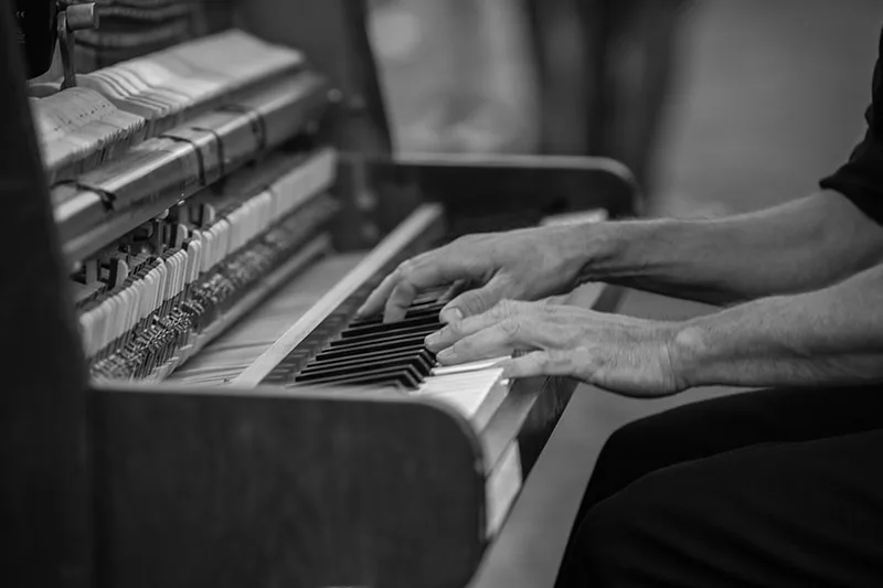Gros plan sur les mains d'un pianiste de rue effleurant les touches de son clavier