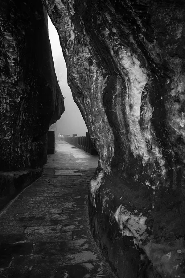 Sentier sinueux et mystérieux s'enfonçant dans les rochers embrumés de Bastei