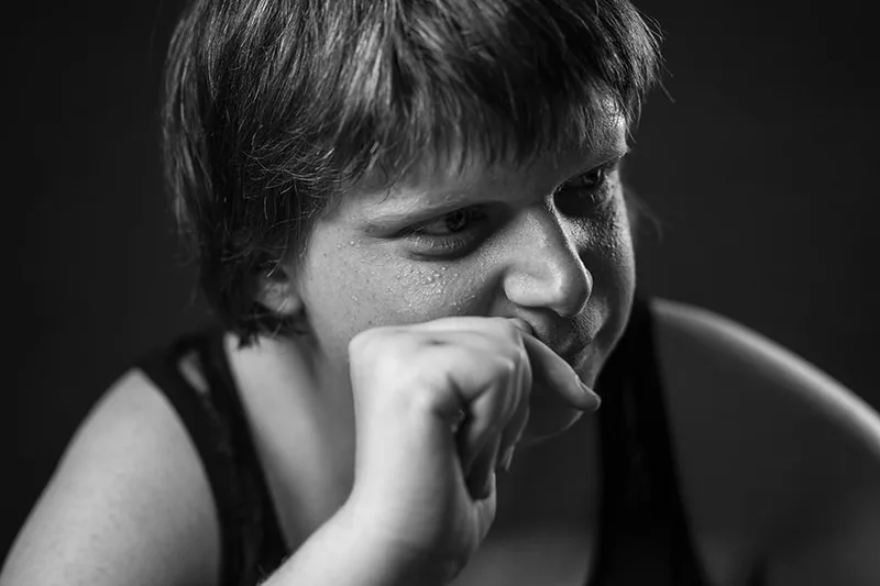 Portrait malicieux d'une personne en situation de handicap affichant un sourire complice