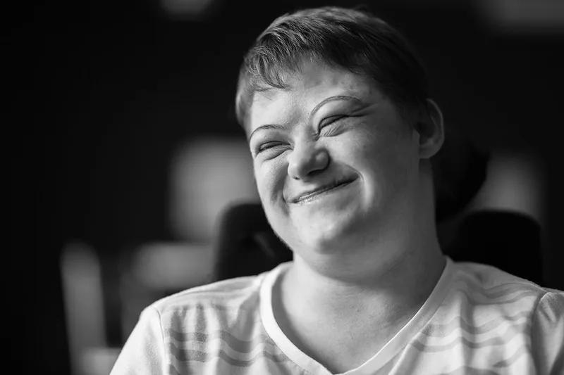Portrait documentaire saisissant le sourire authentique et l'émotion d'une résidente en structure spécialisée