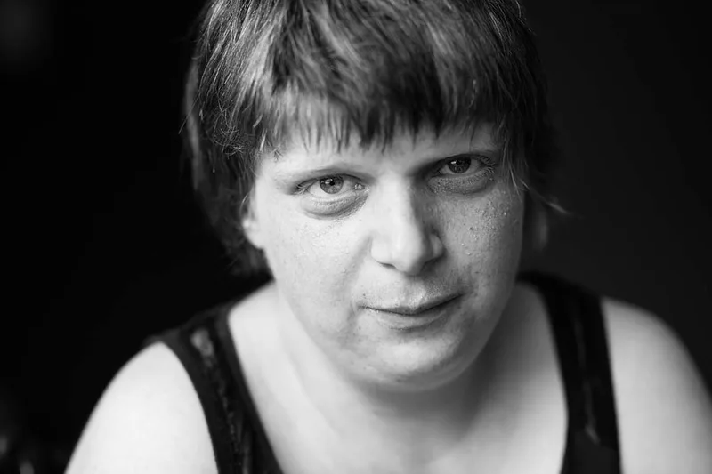 Portrait frontal en noir et blanc d'une résidente au regard franc et aux yeux droits