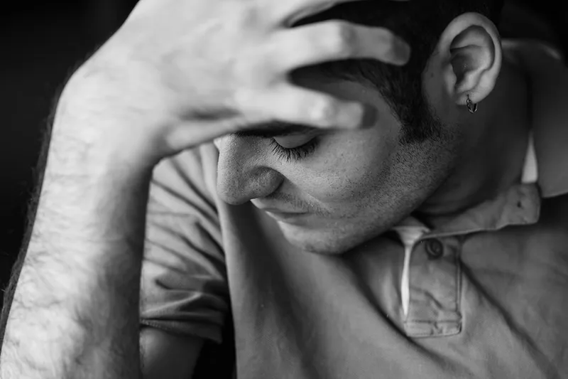 Portrait serré axé sur l'émotion d'un visage et d'une main, témoignant du quotidien en Maison d'Accueil Spécialisée