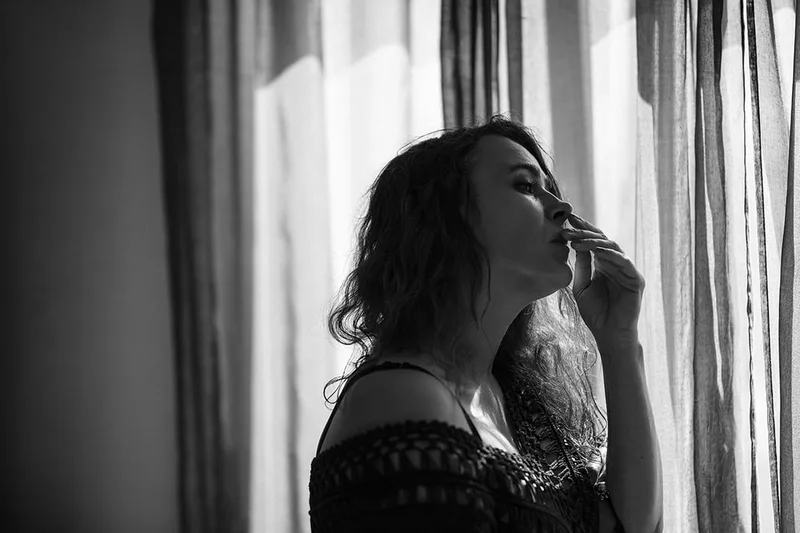 Jeu d'ombres et de lumières naturelles à travers un rideau pour une ambiance boudoir tamisée