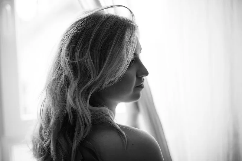 Portrait intimiste féminin en noir et blanc mêlant douceur et sensualité en lumière naturelle