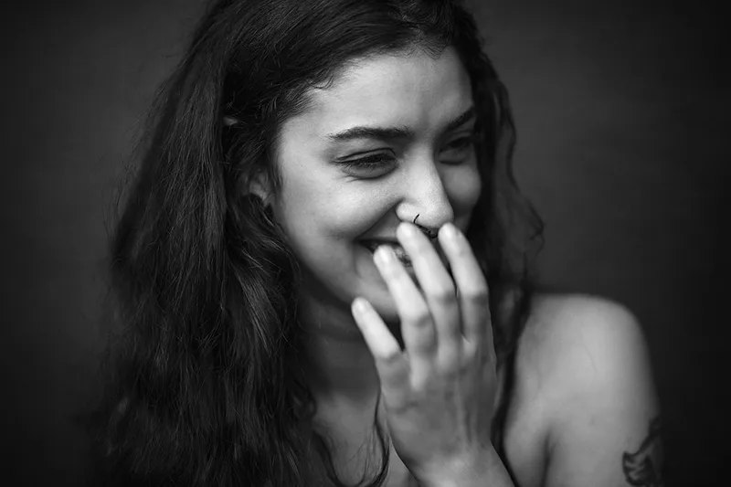 Portrait intimiste noir et blanc révélant un éclat de rire authentique en studio