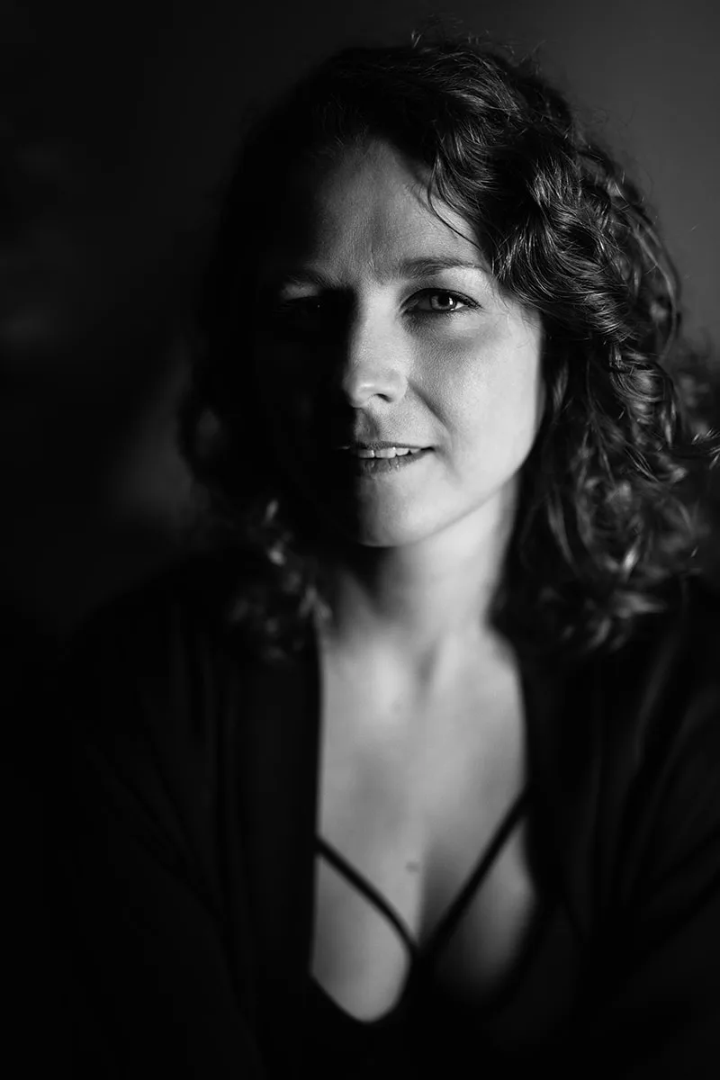 Portrait sensuel en clair-obscur dévoilant le sourire et le regard d'une femme