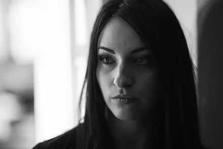 Portrait artistique en noir et blanc d'une femme en contre-jour mettant en valeur son regard