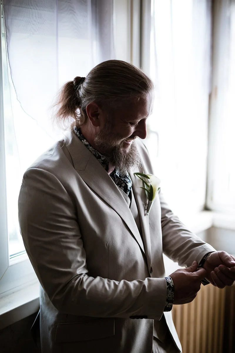 Éclat de rire spontané du marié pendant ses préparatifs de mariage