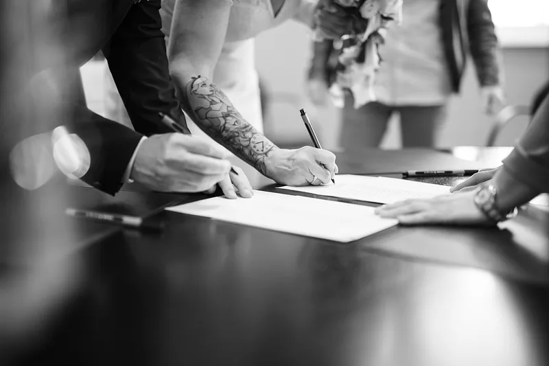 Prise de vue contrastée du moment de la signature des registres à la mairie