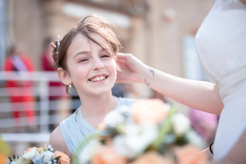 Émotion et complicité entre une mère et sa fille tenant un bouquet de fleurs le jour du mariage