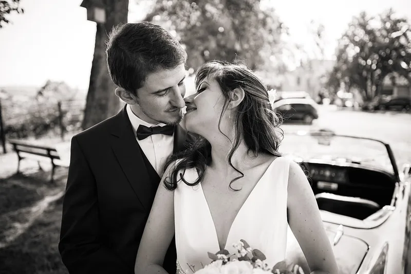Baiser romantique des mariés sur une photo de mariage au style vintage noir et blanc