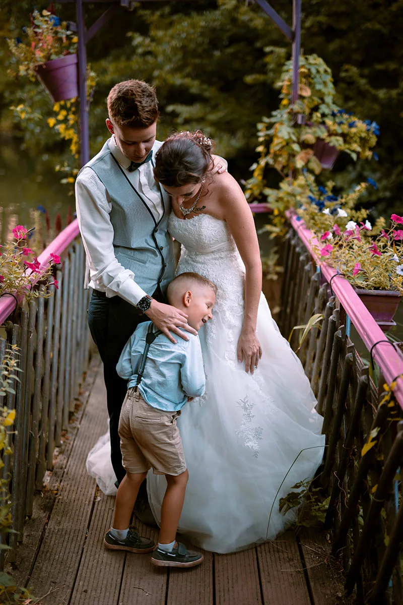 Photo de groupe spontanée en couleur réunissant le couple de mariés et un enfant de la famille