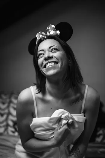 Portrait intimiste en noir et blanc de Minnie souriant aux éclats, démontrant l'importance de la confiance en soi
