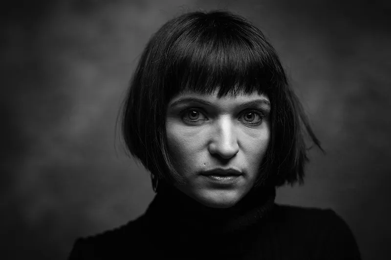 Portrait intimiste et sombre d'une femme en studio de style clair-obscur doux, à Vesoul