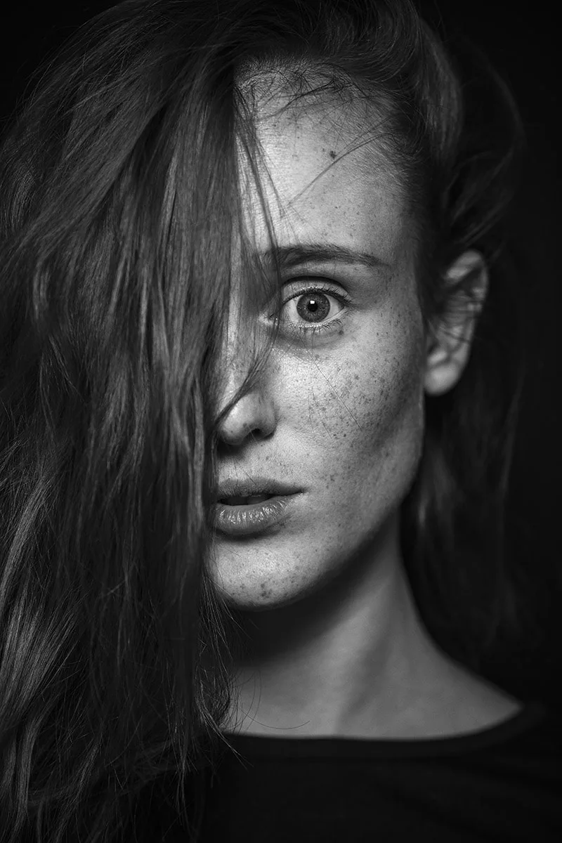 Gros plan artistique sur l'œil et les taches de rousseur d'une femme