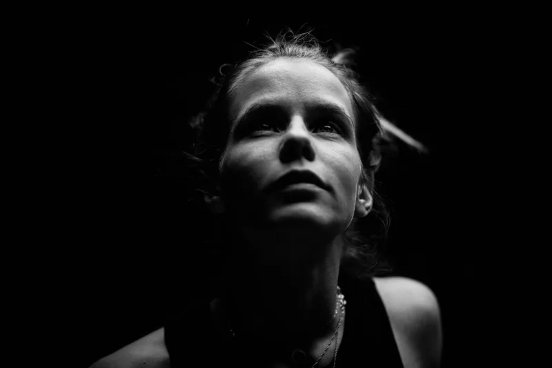 Portrait dramatique low-key d'une femme centré sur l'intensité des yeux