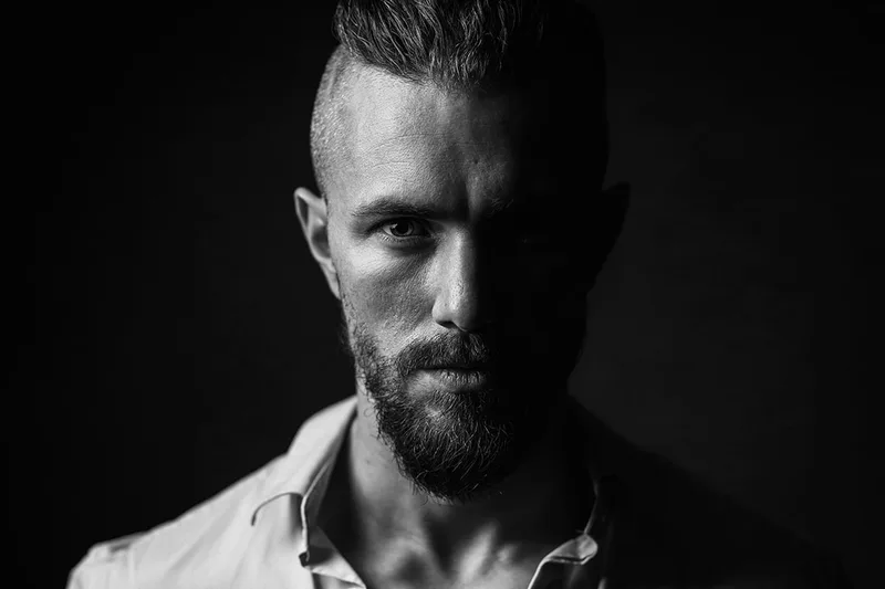 Portrait de mode masculin en studio avec éclairage split low-key, au Luxembourg