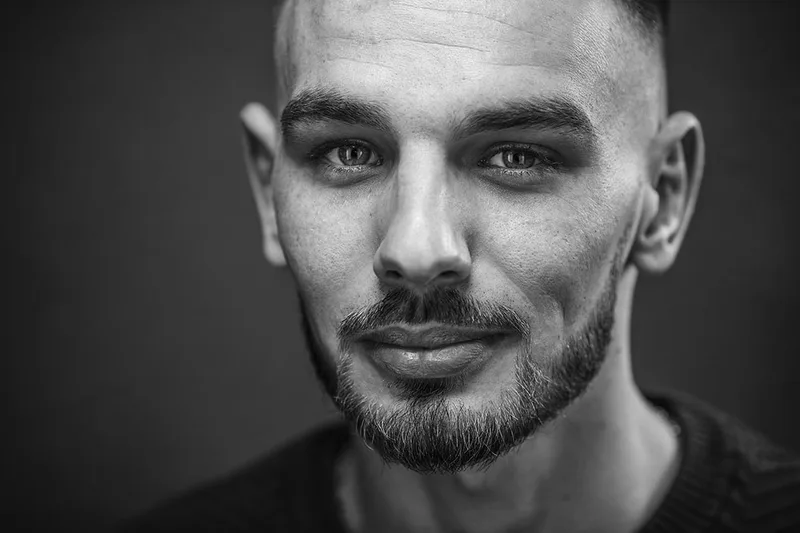 Portrait de studio d'un homme souriant au regard bienveillant