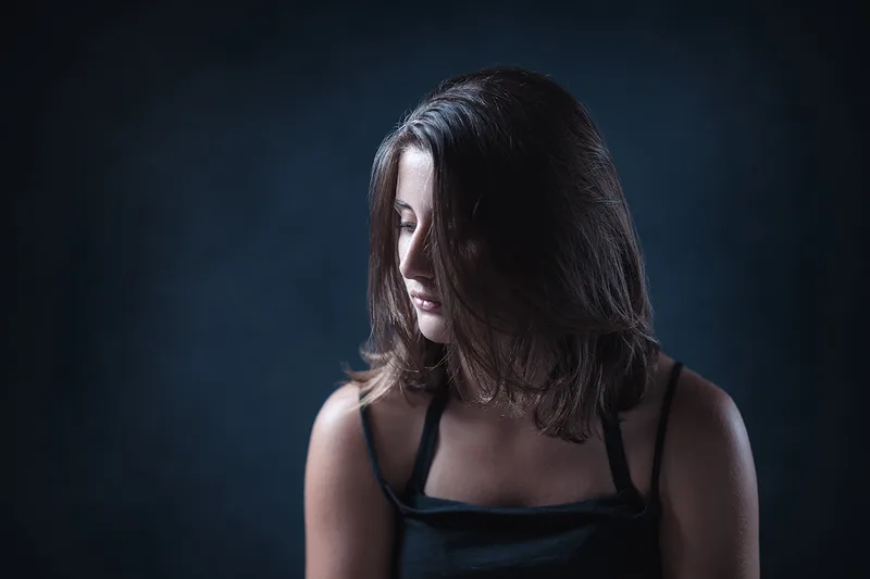 Portrait artistique en couleur d'une femme en clair-obscur, lumière de studio