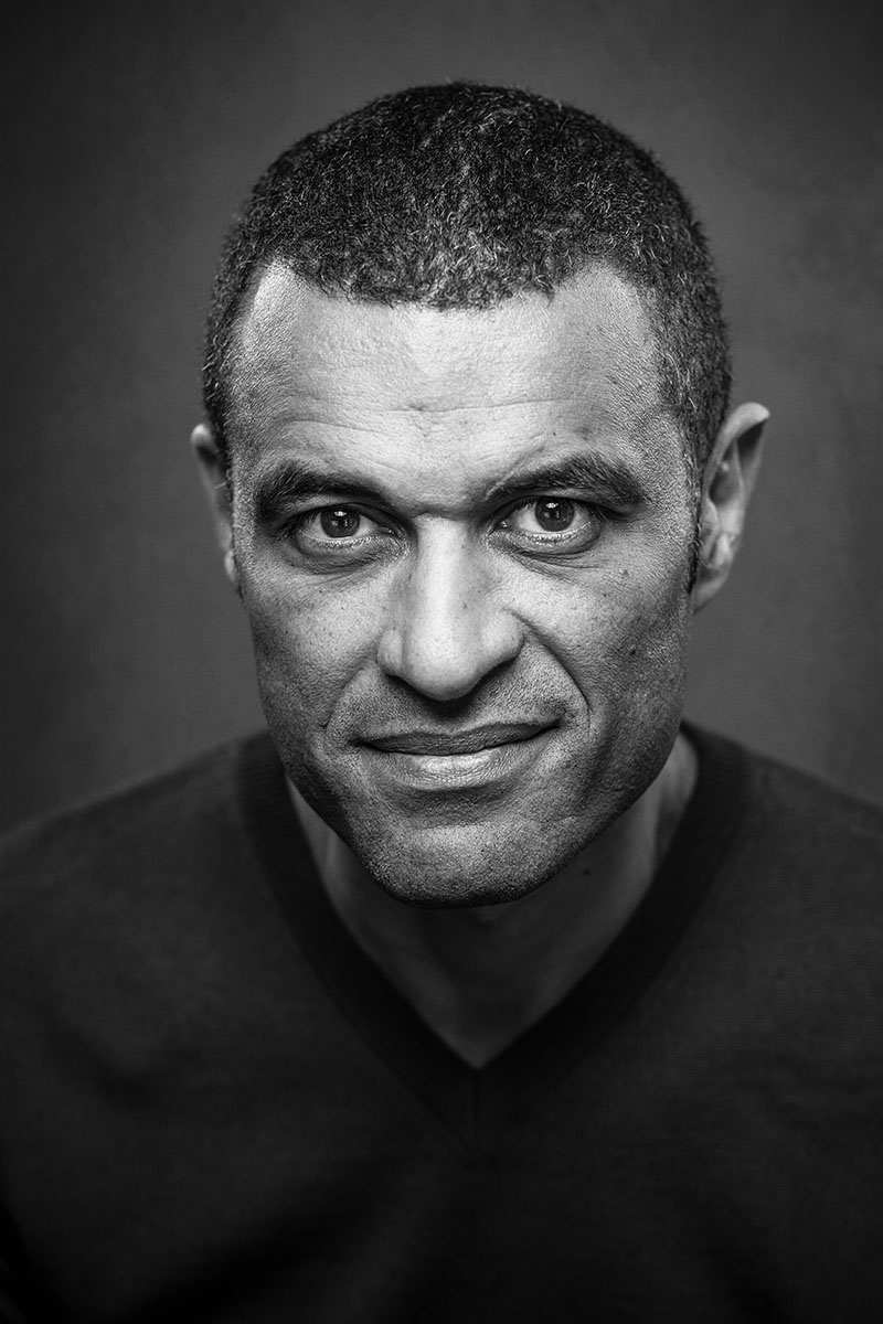 Portrait masculin en noir et blanc, regard direct et expression souriant