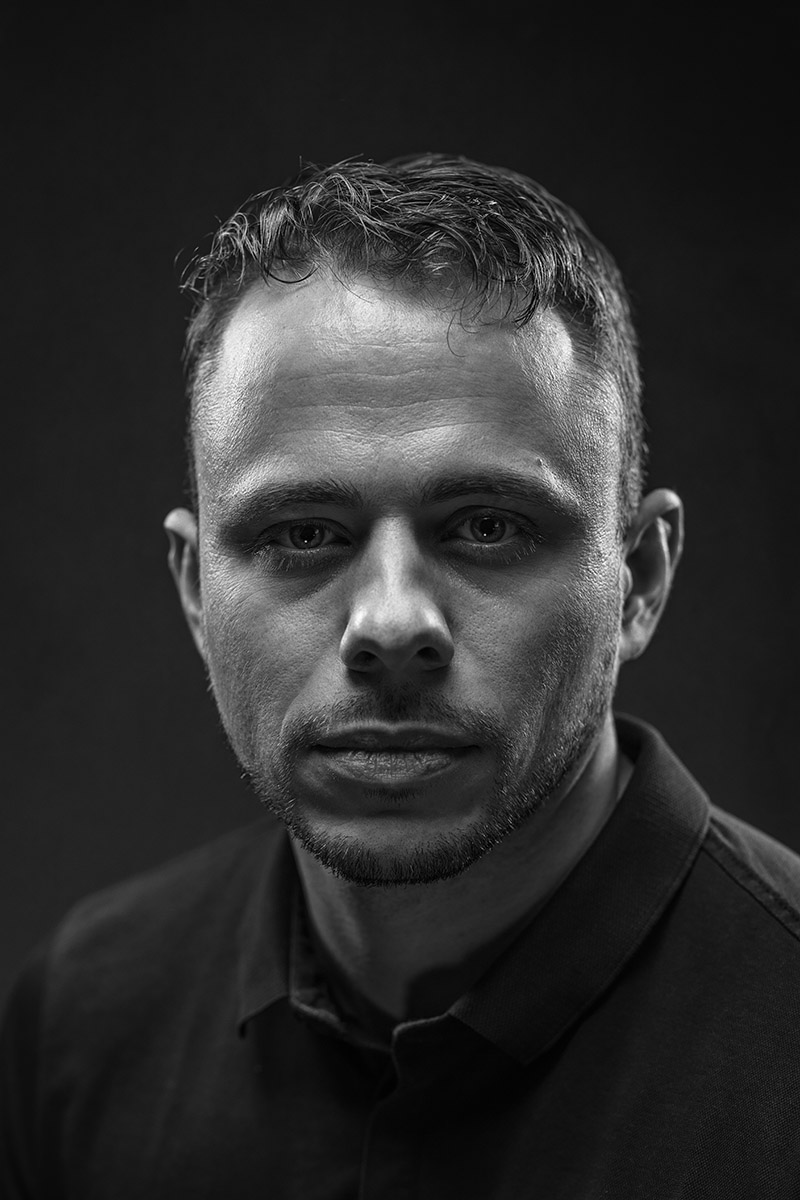 Portrait masculin en noir et blanc, éclairage sombre et regard intense