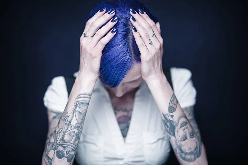 Portrait de mode d'un modèle tatoué mettant en scène le mouvement des mains