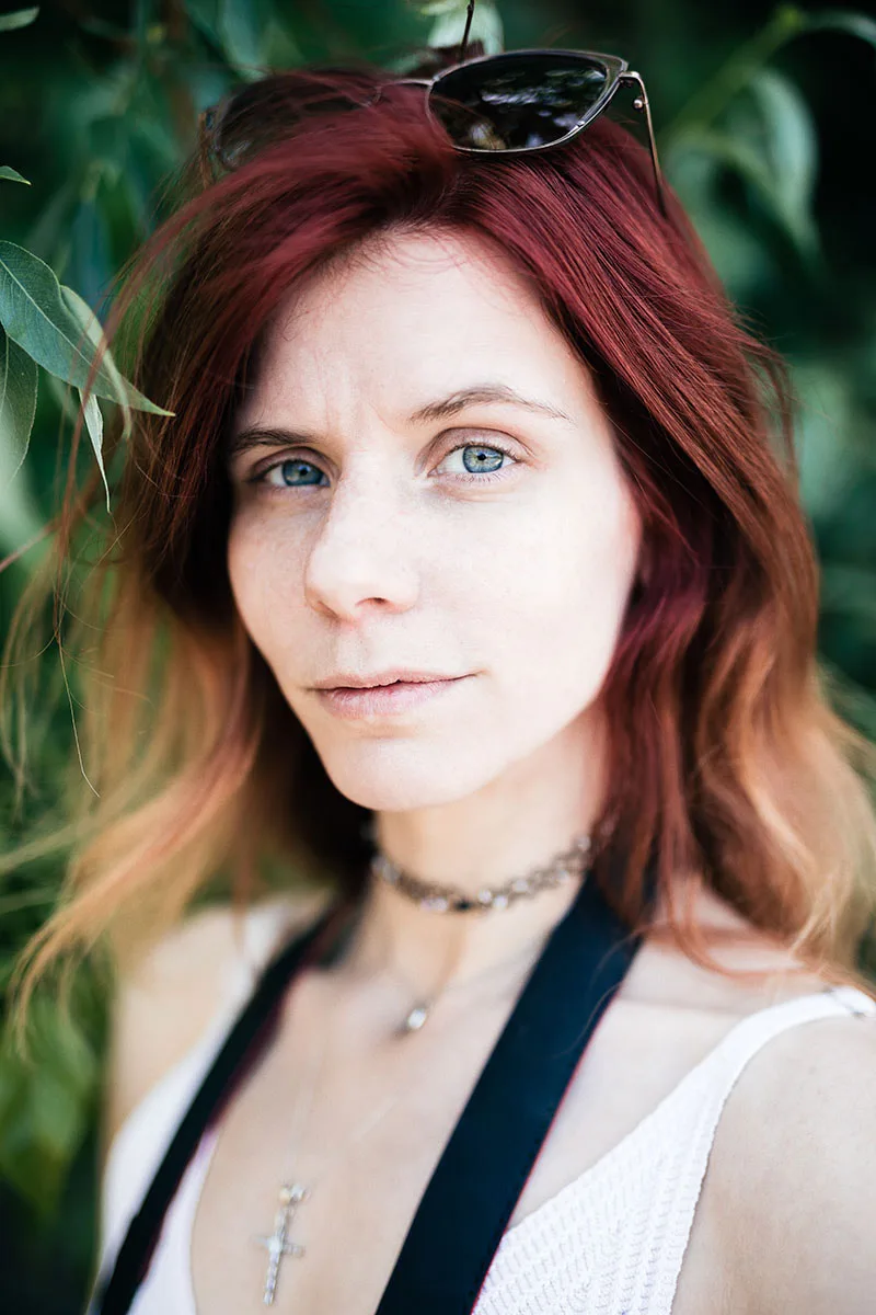 Portrait frontal en lumière naturelle d'une femme rousse au regard direct