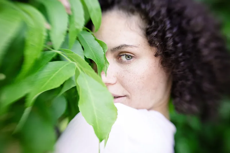 Portrait à travers un feuillage vert avec un effet de flou artistique Lensbaby