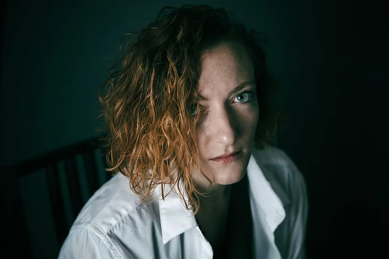 Portrait créatif en studio d'une femme rousse aux yeux bleus
