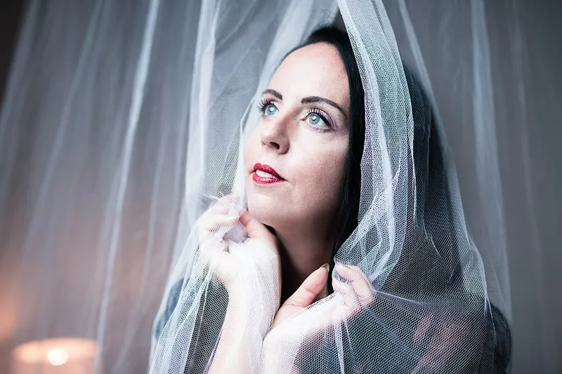 Portrait artistique en studio de la modèle Alexia Wagner jouant avec un tissu