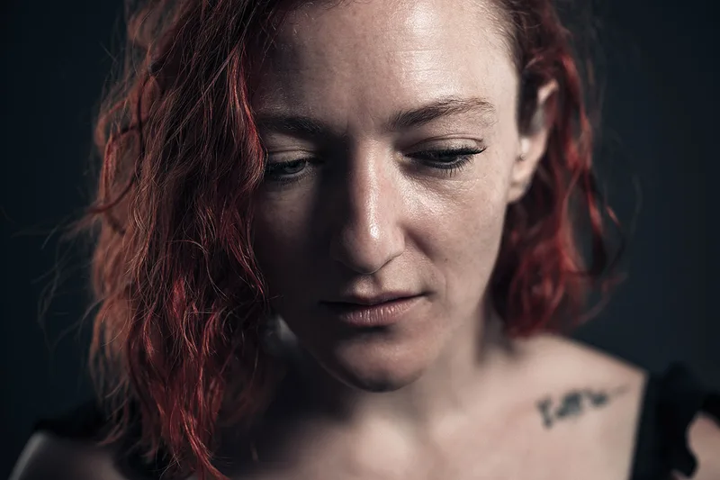 Portrait de studio d'une femme pensive dans une posture d'introspection, à Thionville