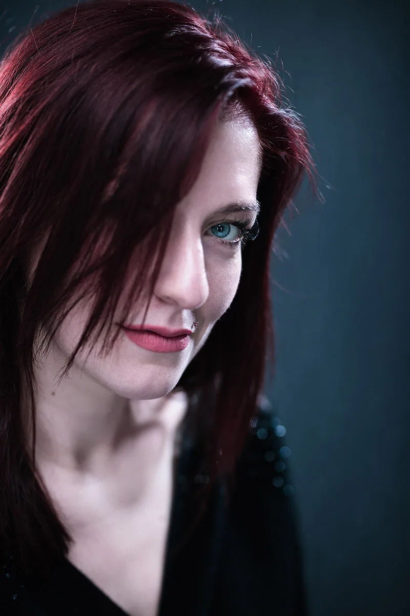 Portrait serré en studio d'une femme rousse au regard bleu intense