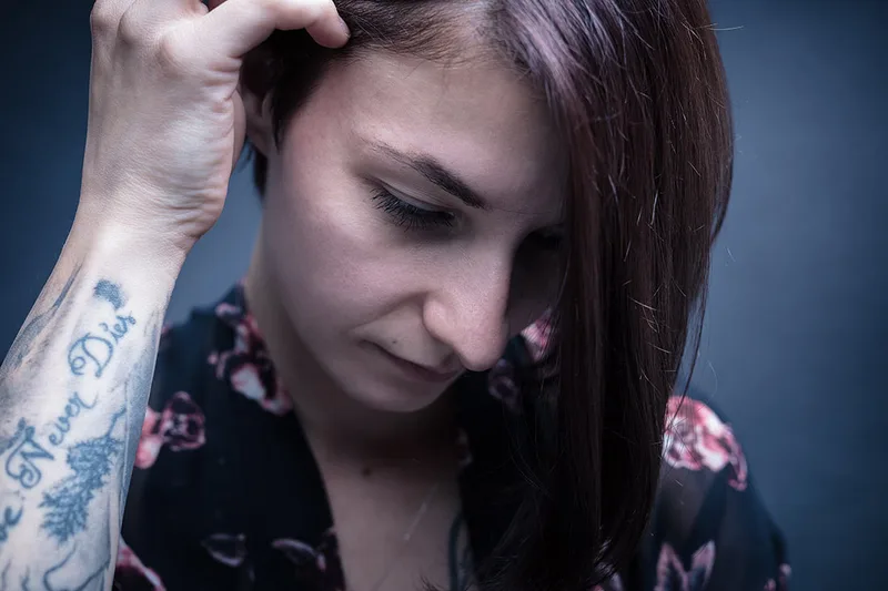 Portrait intimiste mettant en valeur la douceur et les tatouages d'une femme