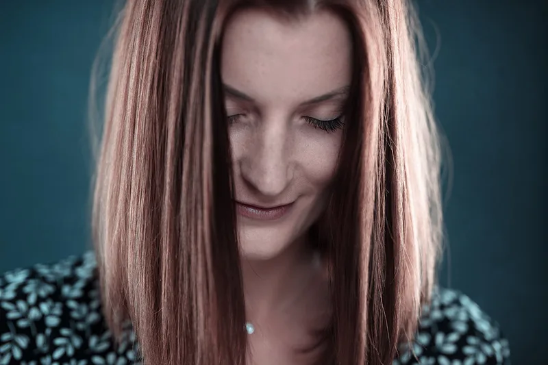 Portrait en lumière naturelle d'une femme rousse pensive