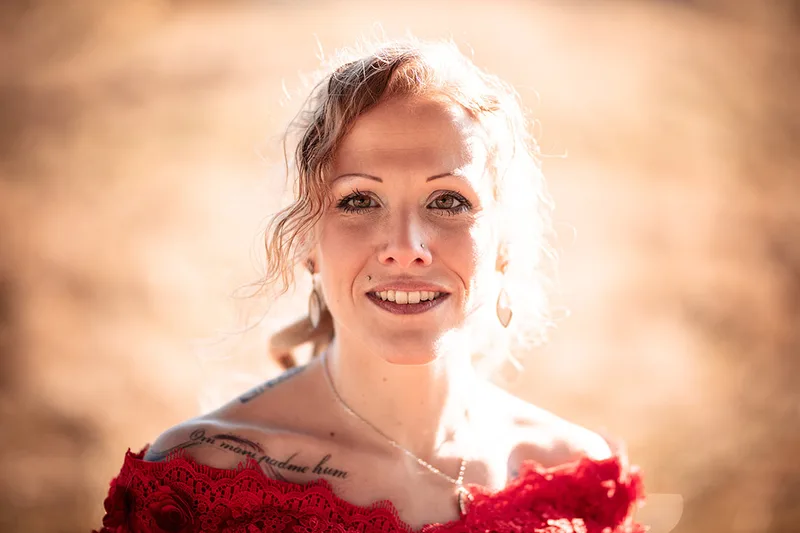 Portrait matinal en robe rouge d'une femme dans une ambiance chaleureuse orange