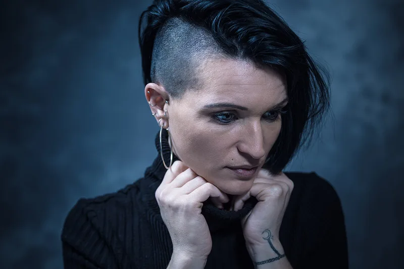 Portrait de studio d'une femme à tatouages, empreint d'émotion