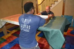  apollo strong moving are movers near me in arlington tx carefully wrapping a table with furniture blankets and shrink wrap