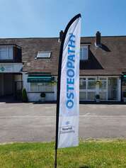Osteopathy Flag in front of the Surrey Injury Clinic  
