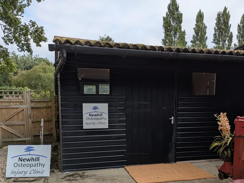 The Newhill Osteopathy @ The Stables, Meath Green Lane, Horley entrance, a professional black timber building with clear signage and a neat gravel approach.