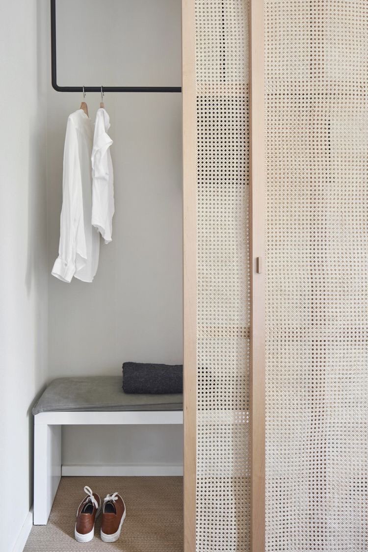 Built-in closet with natural cane door panels and a robe hanging on the door